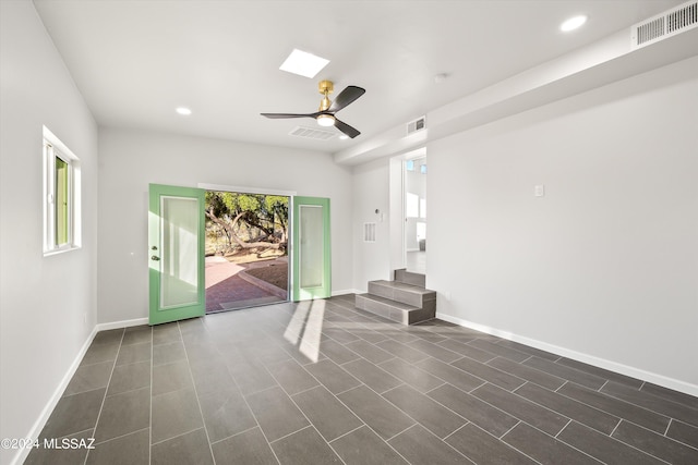 tiled empty room featuring ceiling fan