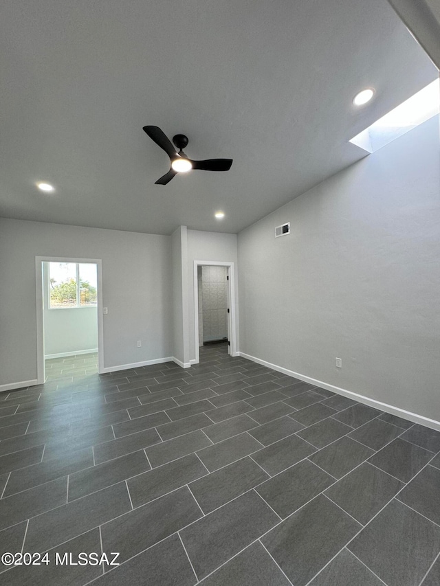 tiled spare room featuring ceiling fan