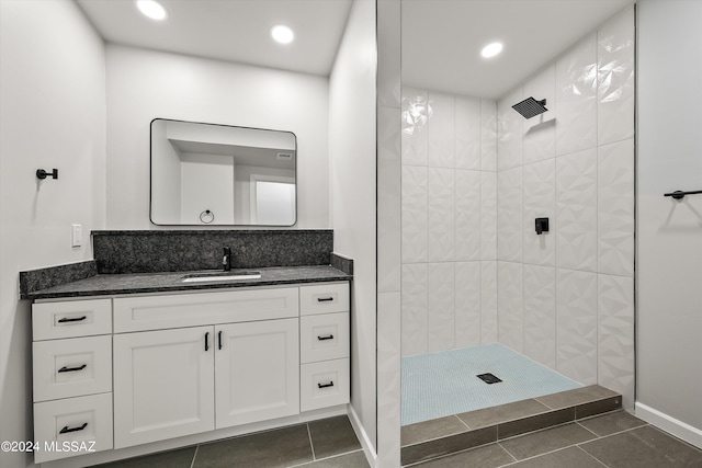 bathroom featuring vanity, tile patterned floors, and a tile shower