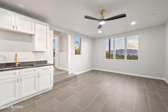 kitchen with sink, ceiling fan, and white cabinetry