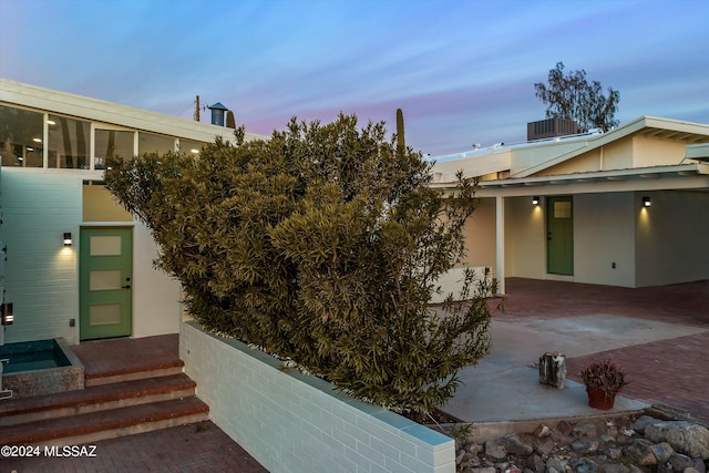 property exterior at dusk with a patio