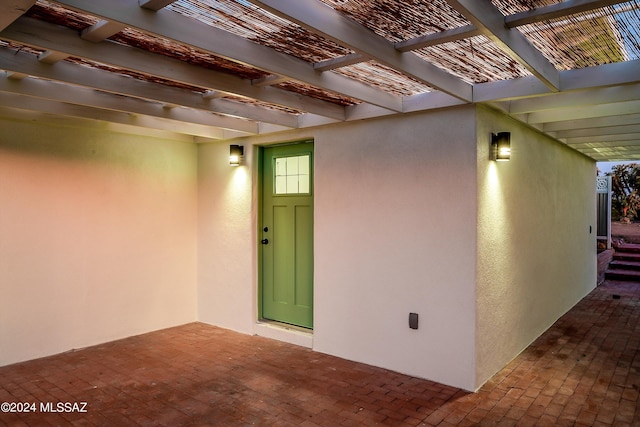 property entrance featuring a pergola and a patio