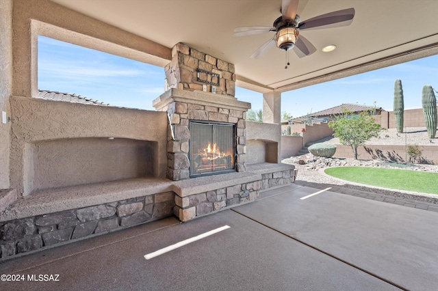 view of patio / terrace with ceiling fan and an outdoor stone fireplace