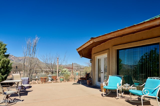 view of terrace with a mountain view and french doors