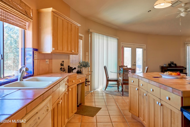 kitchen featuring backsplash, ceiling fan, sink, light tile floors, and french doors