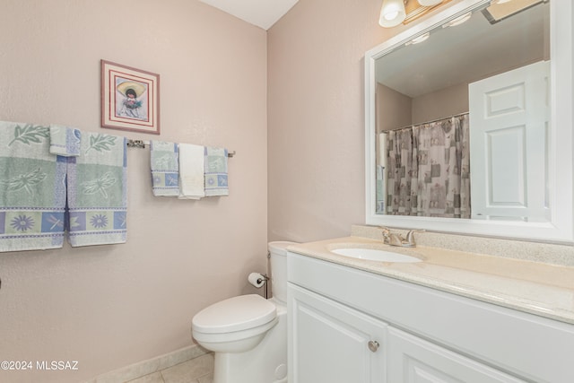 bathroom with tile patterned flooring, vanity, and toilet