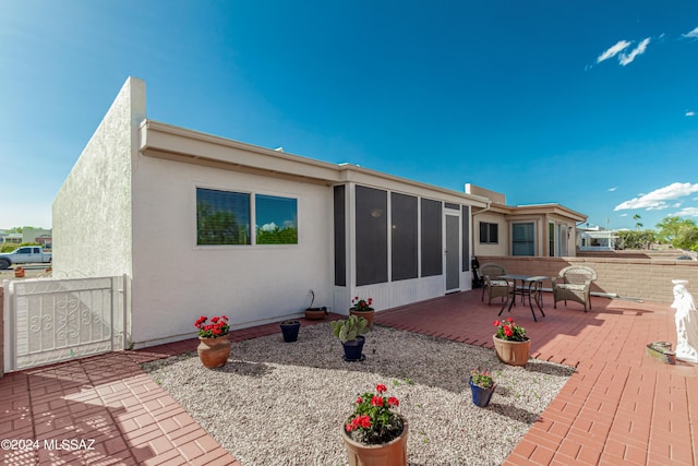 back of property with a patio area and a sunroom