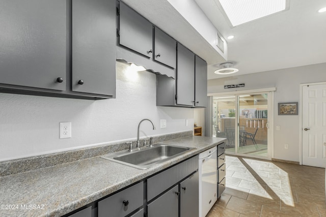 kitchen featuring white dishwasher, gray cabinets, light tile patterned flooring, and sink