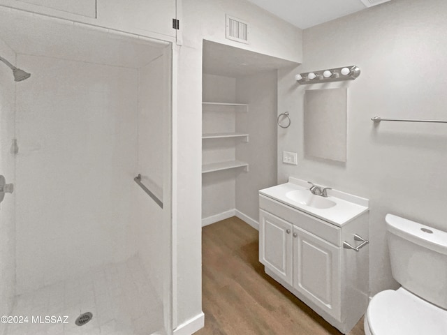 bathroom featuring vanity, hardwood / wood-style flooring, toilet, and walk in shower