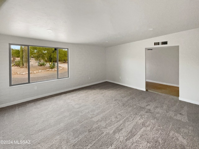 carpeted spare room featuring vaulted ceiling