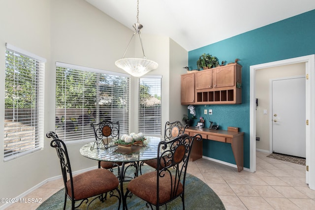 tiled dining room featuring vaulted ceiling