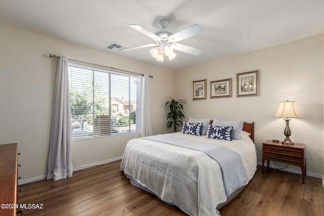 bedroom with dark hardwood / wood-style floors and ceiling fan