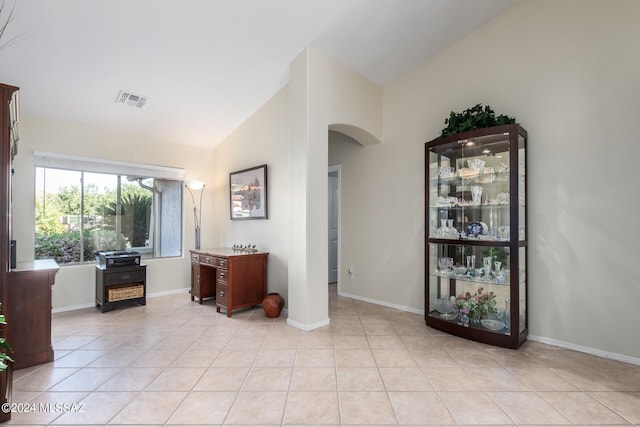 interior space with light tile patterned flooring and vaulted ceiling