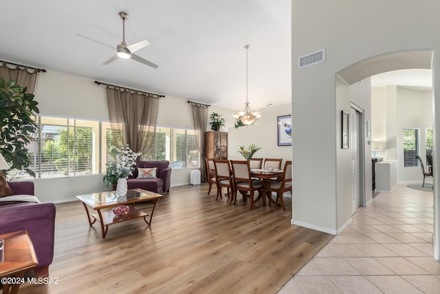 living room featuring light hardwood / wood-style floors and ceiling fan with notable chandelier