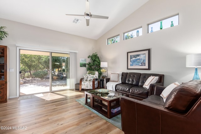 living room with ceiling fan, a healthy amount of sunlight, high vaulted ceiling, and light hardwood / wood-style flooring