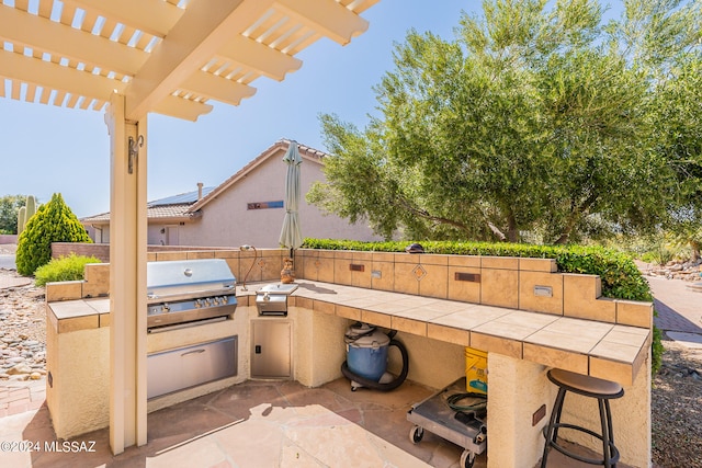 view of patio featuring exterior kitchen, a grill, an outdoor bar, and a pergola