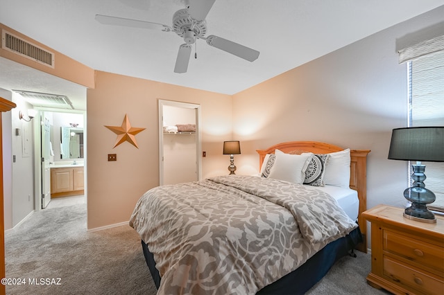 carpeted bedroom featuring connected bathroom, ceiling fan, a closet, and a walk in closet