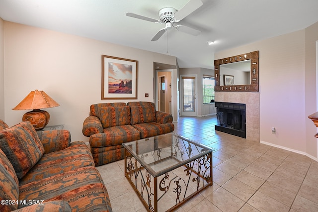 tiled living room with ceiling fan and a fireplace