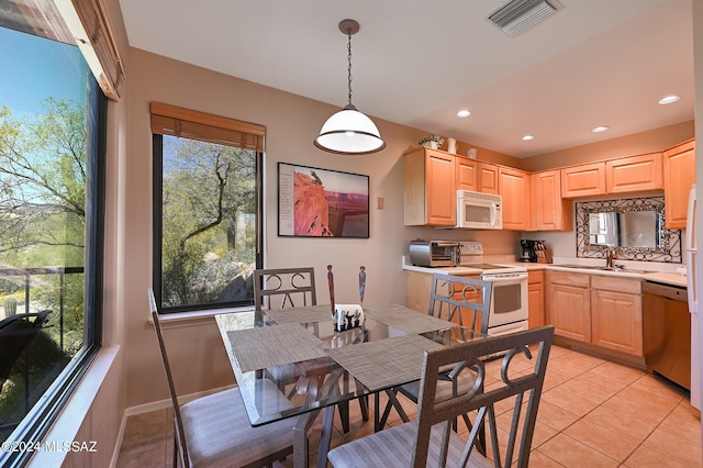 dining area featuring sink and light tile flooring