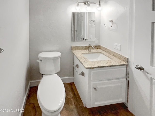 bathroom featuring tile flooring, toilet, and vanity