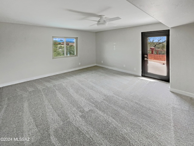 carpeted spare room featuring ceiling fan