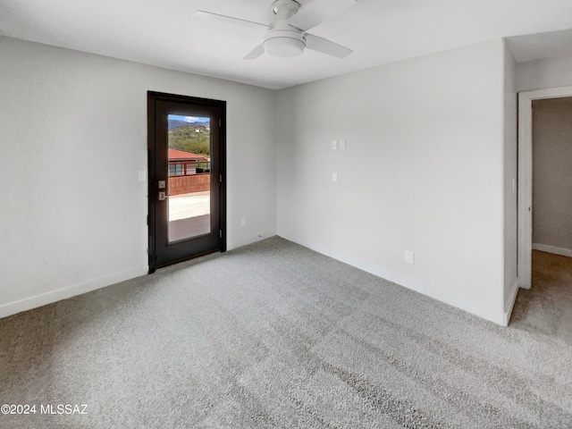 carpeted spare room with ceiling fan