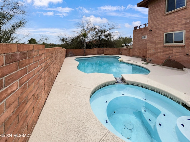 view of pool with an in ground hot tub