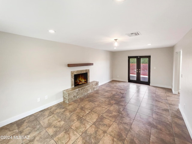 unfurnished living room with dark tile flooring and french doors