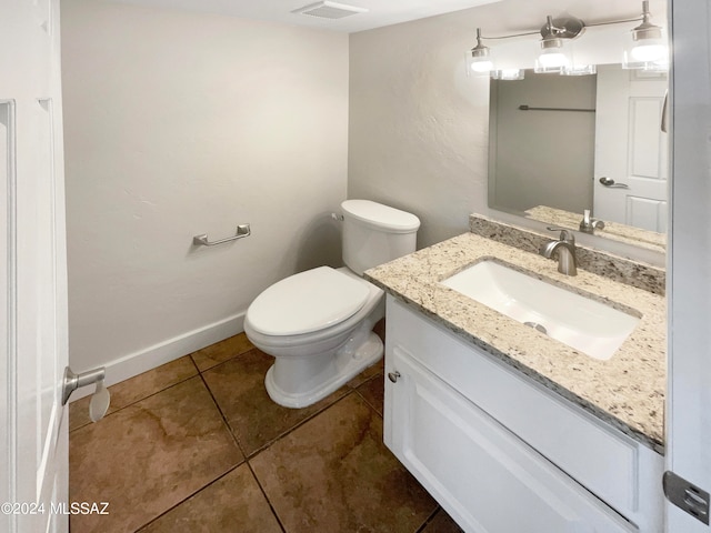 bathroom featuring toilet, large vanity, and tile flooring