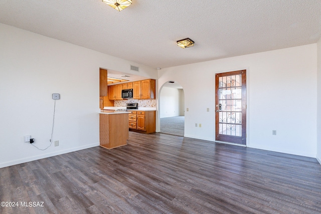 unfurnished living room with dark hardwood / wood-style flooring and a textured ceiling