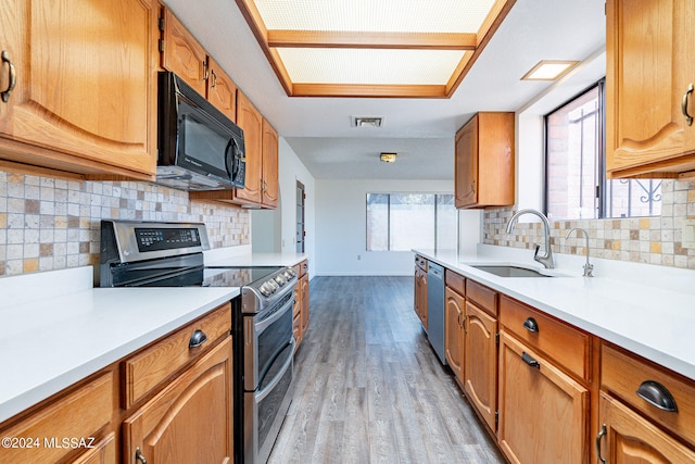 kitchen featuring sink, light hardwood / wood-style floors, tasteful backsplash, and stainless steel appliances