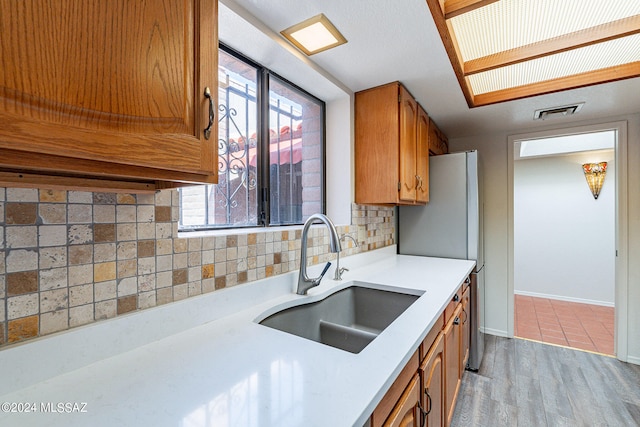 kitchen featuring backsplash, sink, and light hardwood / wood-style floors