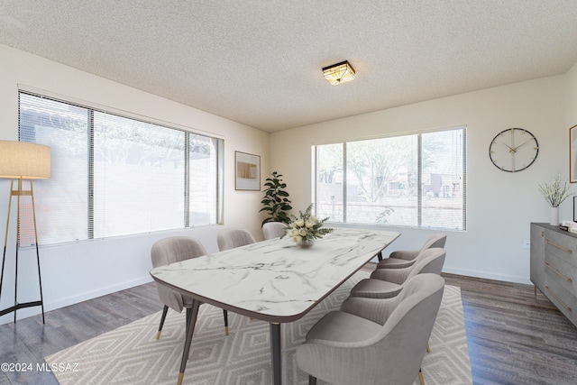 dining space with dark hardwood / wood-style flooring and a textured ceiling