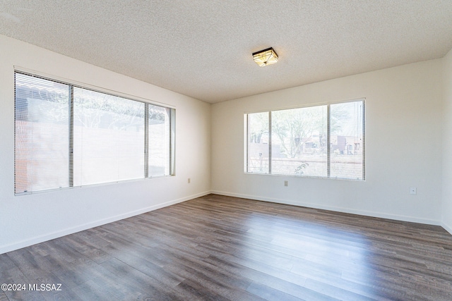 empty room featuring dark hardwood / wood-style flooring and a textured ceiling