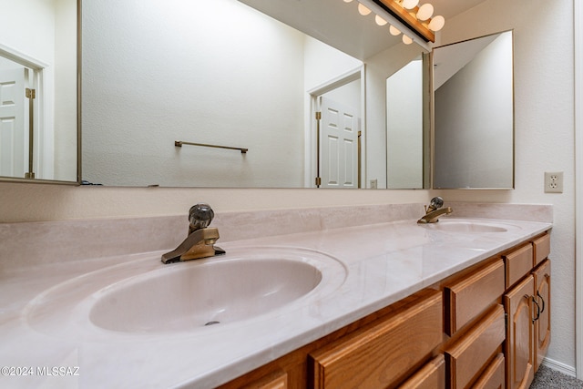 bathroom with dual sinks and vanity with extensive cabinet space