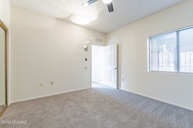 carpeted empty room with a textured ceiling and ceiling fan