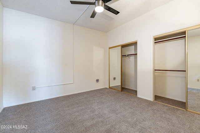 unfurnished bedroom featuring ceiling fan, carpet flooring, and multiple closets