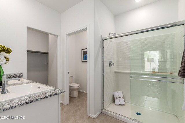 bathroom featuring vanity, tile patterned flooring, toilet, and an enclosed shower