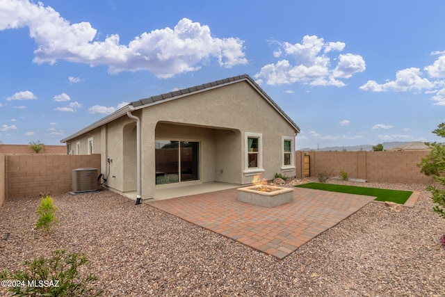 back of property featuring an outdoor fire pit, a fenced backyard, central AC, stucco siding, and a patio area