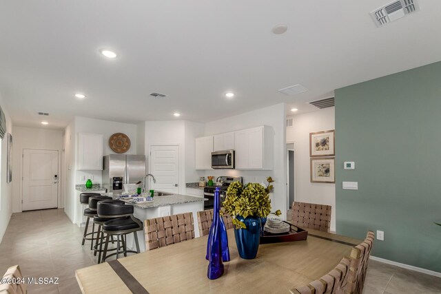 dining area featuring light tile patterned flooring and sink