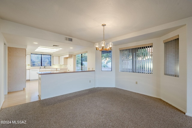 interior space featuring light carpet and a notable chandelier