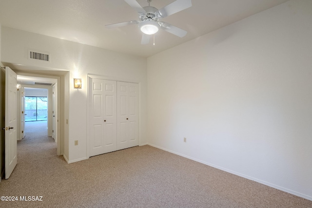 unfurnished bedroom featuring light colored carpet, a closet, and ceiling fan