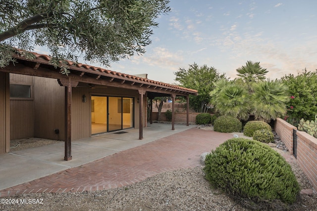 back house at dusk with a patio