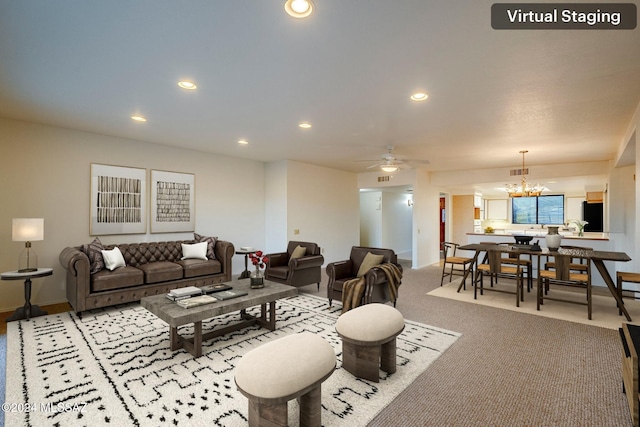 living room featuring carpet floors and ceiling fan with notable chandelier