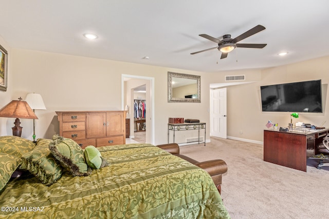 carpeted bedroom featuring a closet, a spacious closet, and ceiling fan