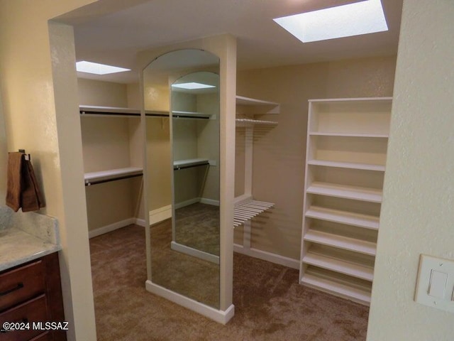 walk in closet featuring a skylight and carpet