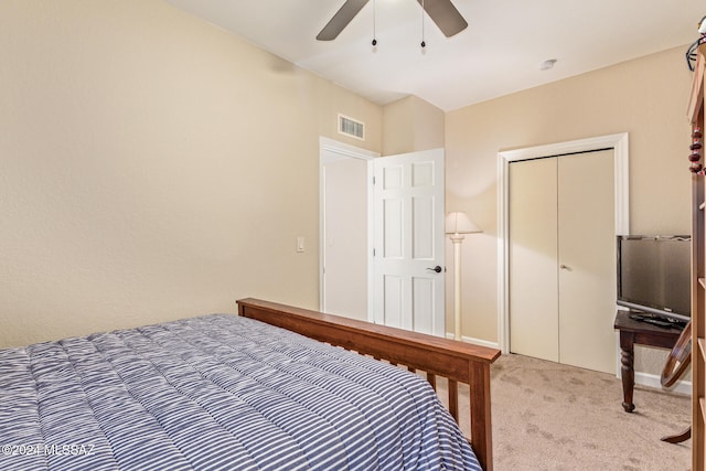 bedroom featuring ceiling fan, light carpet, and a closet