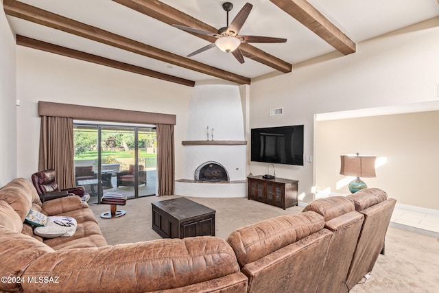 living room with beamed ceiling, light colored carpet, ceiling fan, and a fireplace