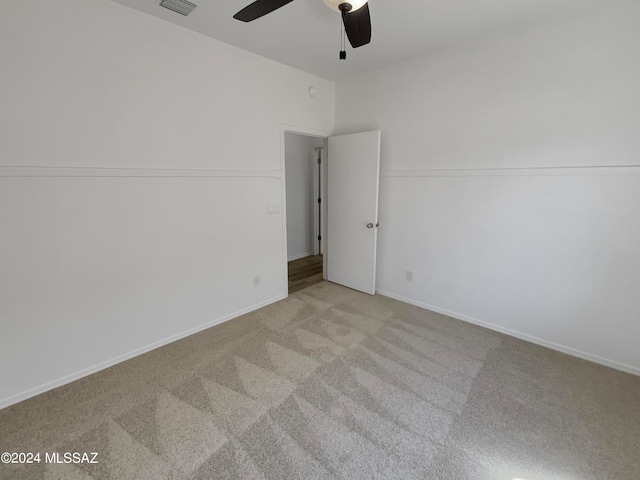 spare room featuring light colored carpet and ceiling fan