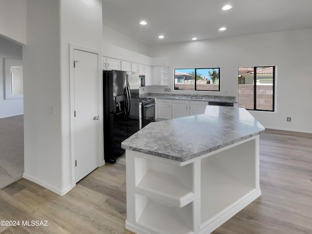 kitchen featuring white cabinetry, light hardwood / wood-style floors, black appliances, and sink